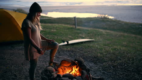 an attractive young woman roasting marshmallows by