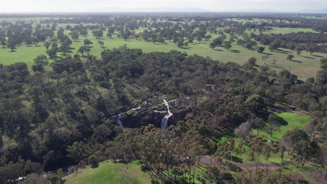 Aerial view and panning down over Nigretta Falls, along the Wannon River, near Hamilton, Victoria, Australia. June 2023.