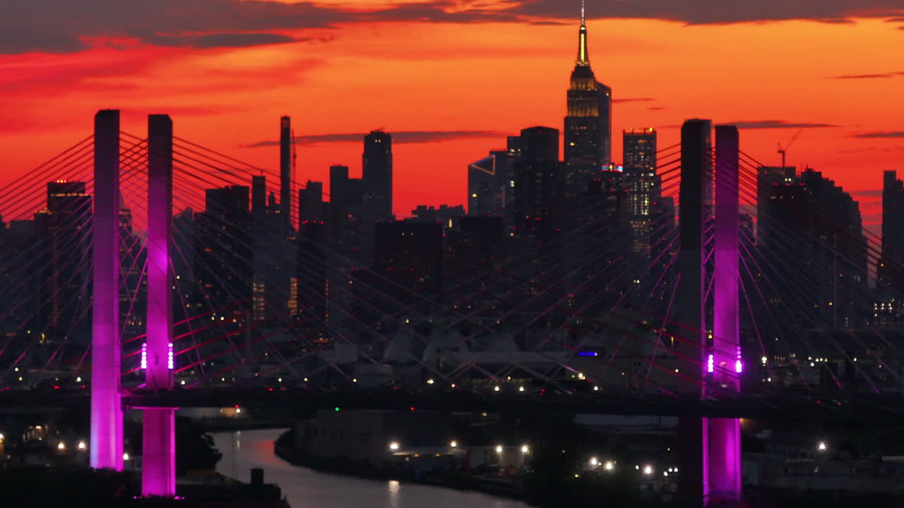Aerial view of New York City's Kosciuszko Bridge at night. The bridge spans Newton Creek connecting Queens and Brooklyn.