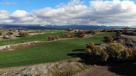 Aerial:-flying-over-meadows-with-mountains-and-some-clouds-in-the-background-in-Catalonia