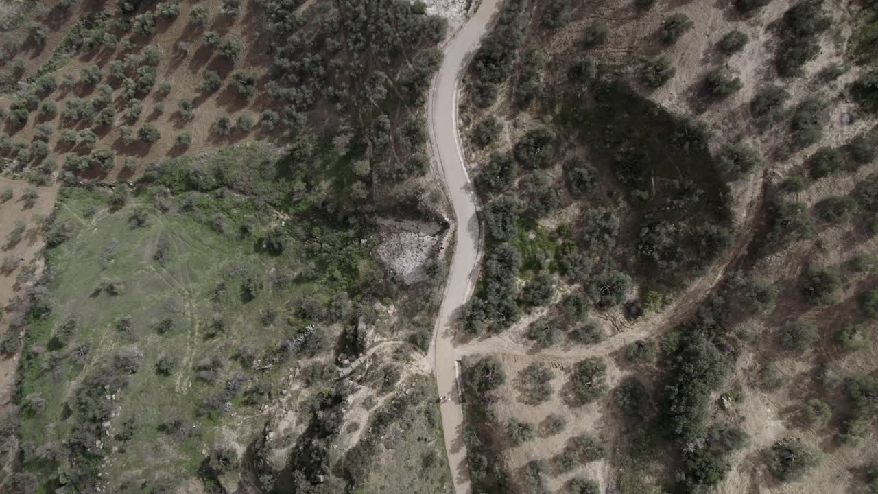 Ascending top-down 4K aerial view of Olvera, Spain, filmed with a DJI drone at 30fps. A cinematic shot revealing the vast meadows and natural beauty of the Spanish countryside.