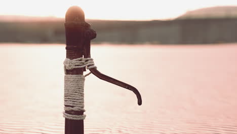 Rusty-old-metal-water-pump-on-sand-beach