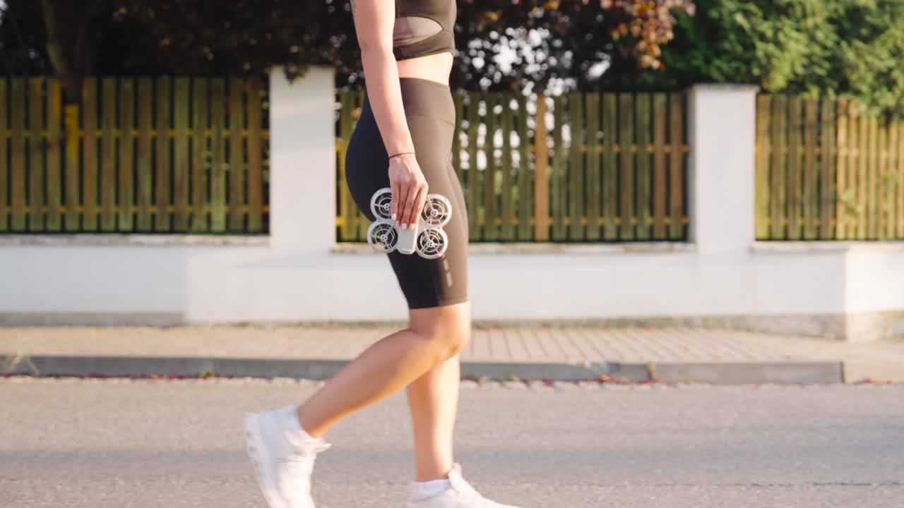 Woman Walking and Holding a Drone