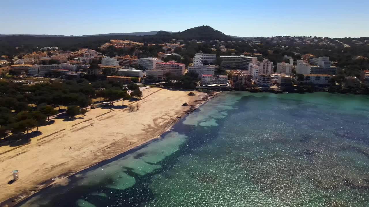 Enjoy a stunning view of Santa Ponsa beach in Mallorca, showcasing the clear turquoise waters and the vibrant coastline. Ideal for relaxation and beach activities under the sun.