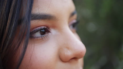 close up of the face and eyes of a beautiful adult hispanic woman staring and looking with a calm genuine human feeling