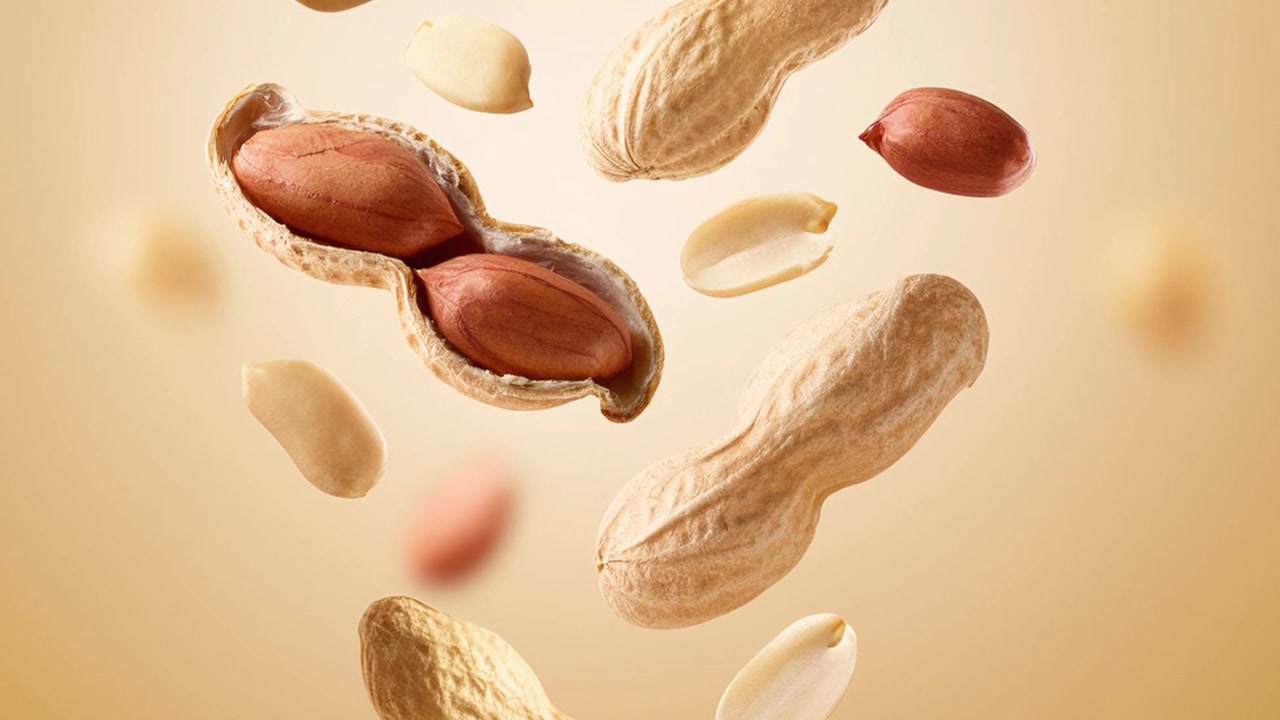 Arachidi fresche fluttuanti con gusci in movimento su sfondo beige