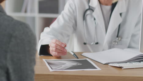 mature female doctor or consultant meeting with female patient wearing headscarf to discuss scans