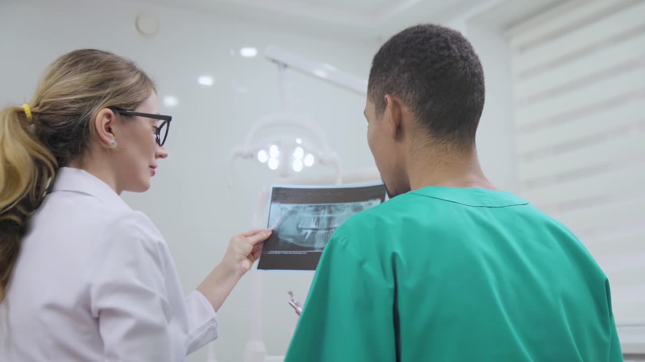 Caucasian female dentist explaining to student x-ray