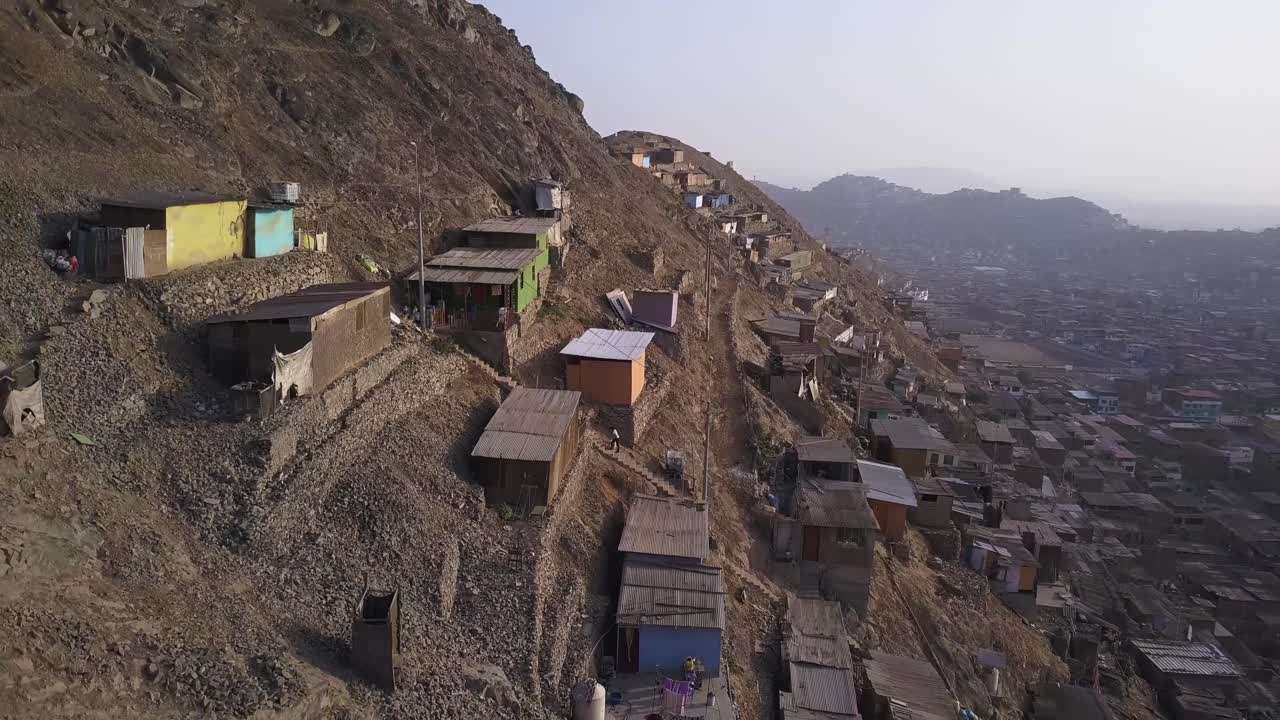 Precarious hillside dwellings with vibrant facades contrast against the harsh, arid landscape. A striking image for social studies, urbanization topics, and economic disparity projects.