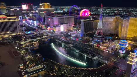 las vegas strip por la noche con la fuente de bellagio y la esfera