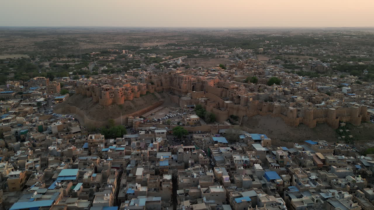 una impresionante vista aérea del fuerte de jaisalmer, rajasthan, india, brillando en piedra arenisca dorada bajo la luz del día. rodeado de casas densamente abarrotadas 4k