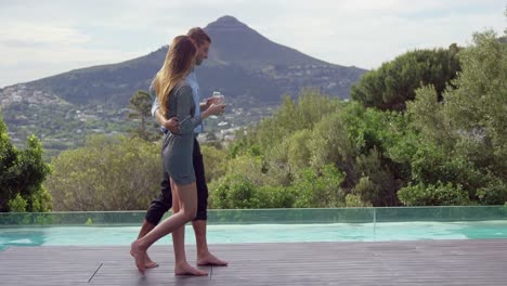 pareja caminando cerca de la piscina