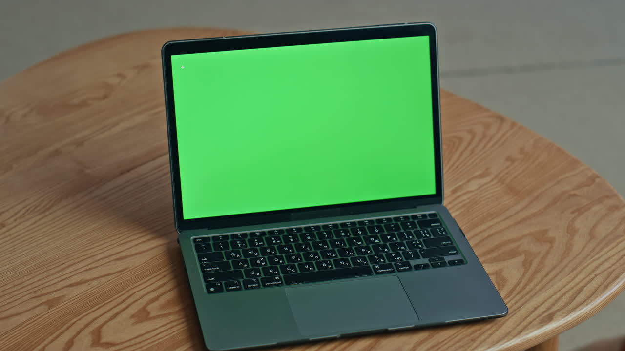 Empty green screen monitor of modern laptop standing wooden office desk closeup