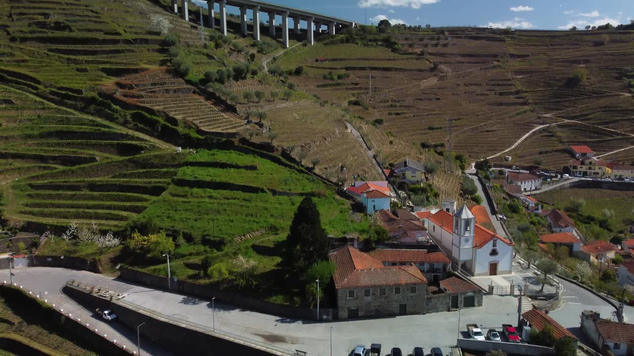 vista dall'alto di una piccola piazza del villaggio con parcheggio presso la chiesa tra le montagne portoghesi vicino al fiume douro nel bellissimo porto turistico settentrionale