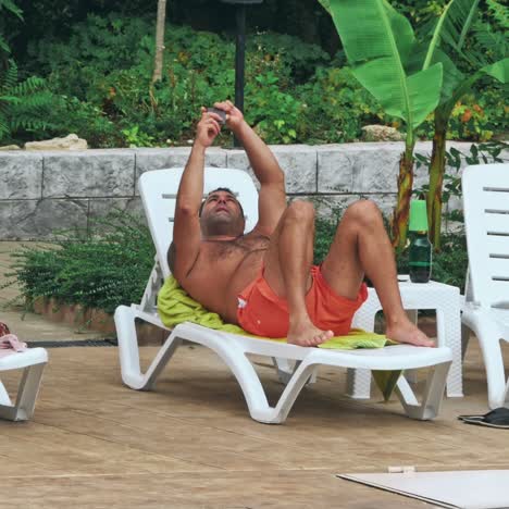 personas sentadas a la orilla de la piscina de un resort durante las vacaciones de verano