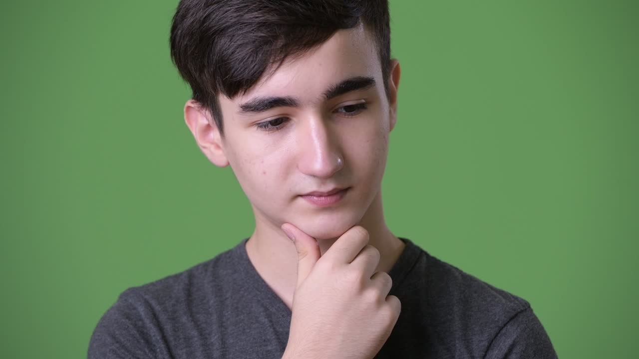 joven y guapo adolescente iraní contra un fondo verde