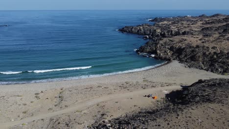 Moto-Turista-Con-Carpa-Naranja-Está-Sola-En-La-Tranquila-Playa-Del-Océano-Creciente