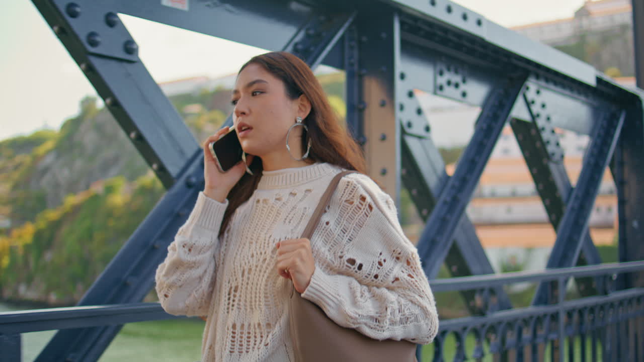 Closeup  woman speaking mobile phone on go on river bridge. Girl talking