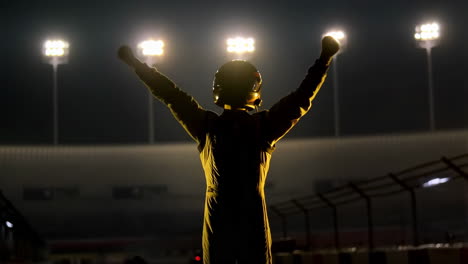 race car driver celebrating victory at night
