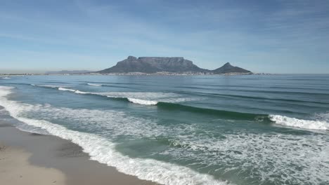 drone shot flying over blouberg beach and approaching table mountain, africa