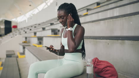 trendy sports woman listening to music through