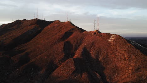 aerial parallax from right to left of el paso mountains with radio towers at sunset