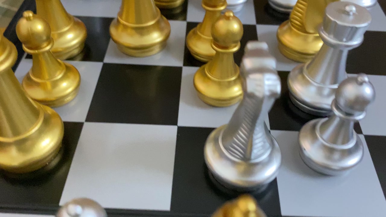 Chess board strategy game with golden and silver chess pieces - close up shot