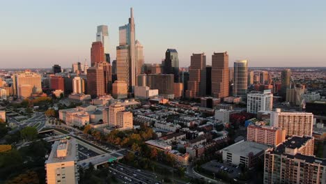 slow aerial dolly forward shot of philadelphia skyline during summer golden hour evening sunset