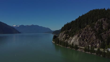 A-breathtaking-4K-aerial-view-of-the-tranquil-beauty-of-nature-in-BC,-Canada:-ocean-waters,-mountain-ranges-and-forests-surrounding-Porto-Cove-Marina