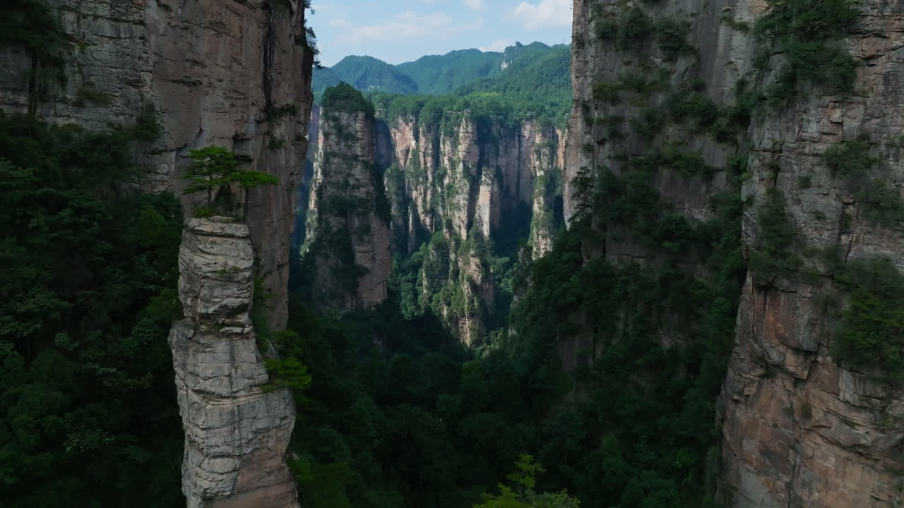 Aerial view flying in middle of limestone mountains in sunny Zhangjiajie, China