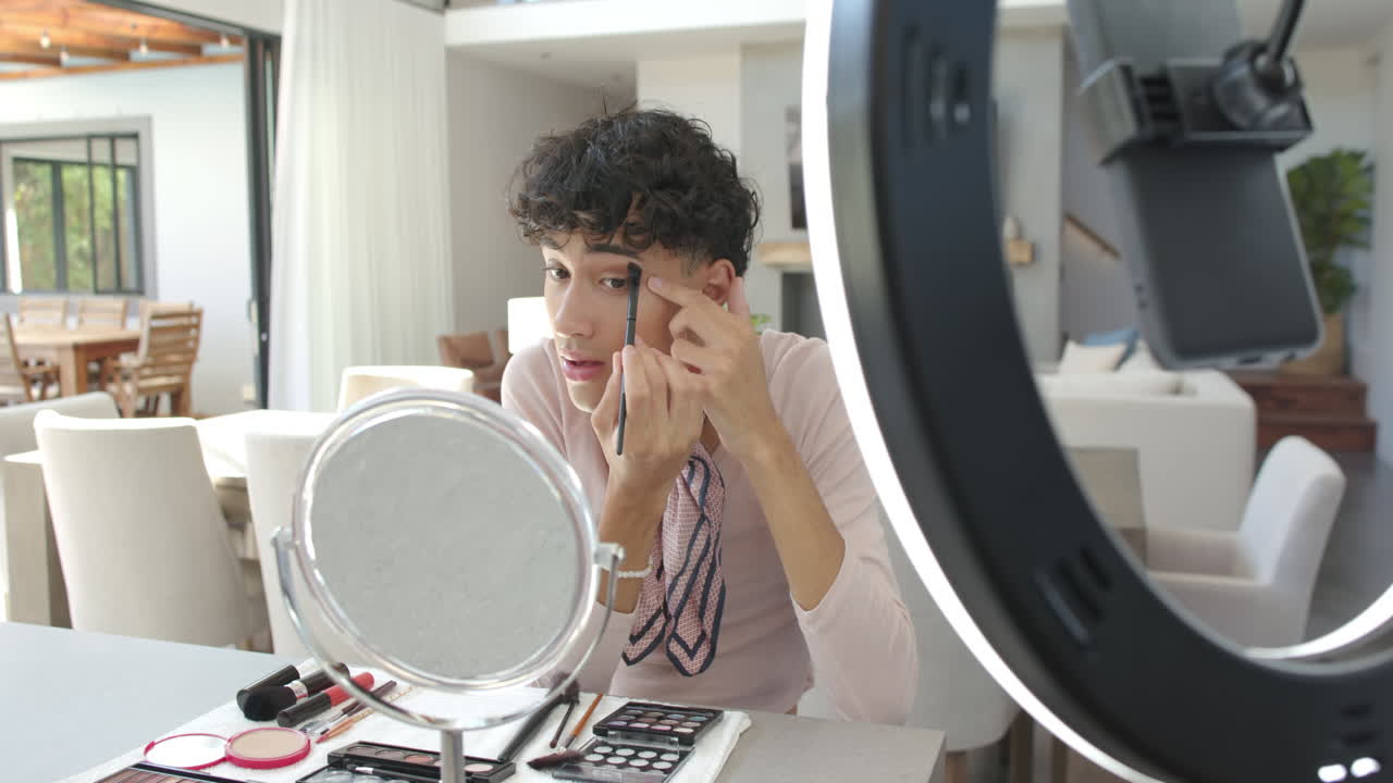 Applying makeup at home, non binary person using mirror and ring light