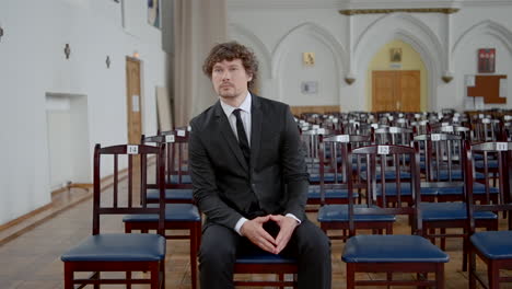 hombre de traje sentado en la iglesia