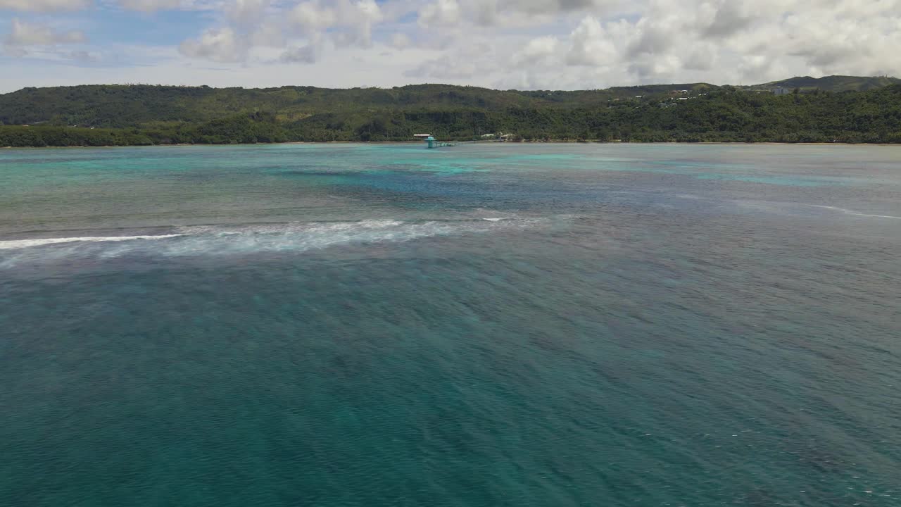 Ripresa con drone sopra acque cristalline e blu al largo dell'isola tropicale di Guam, USA