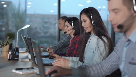 call center team working on laptops with headsets