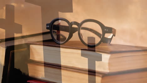 glasses resting on stacked books, cross silhouettes creating animation in background