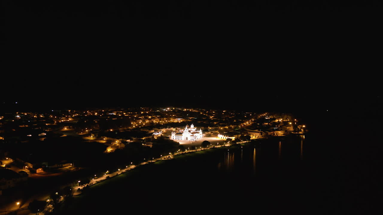aerial drone overall pretty night lights and the white church at El Rocio