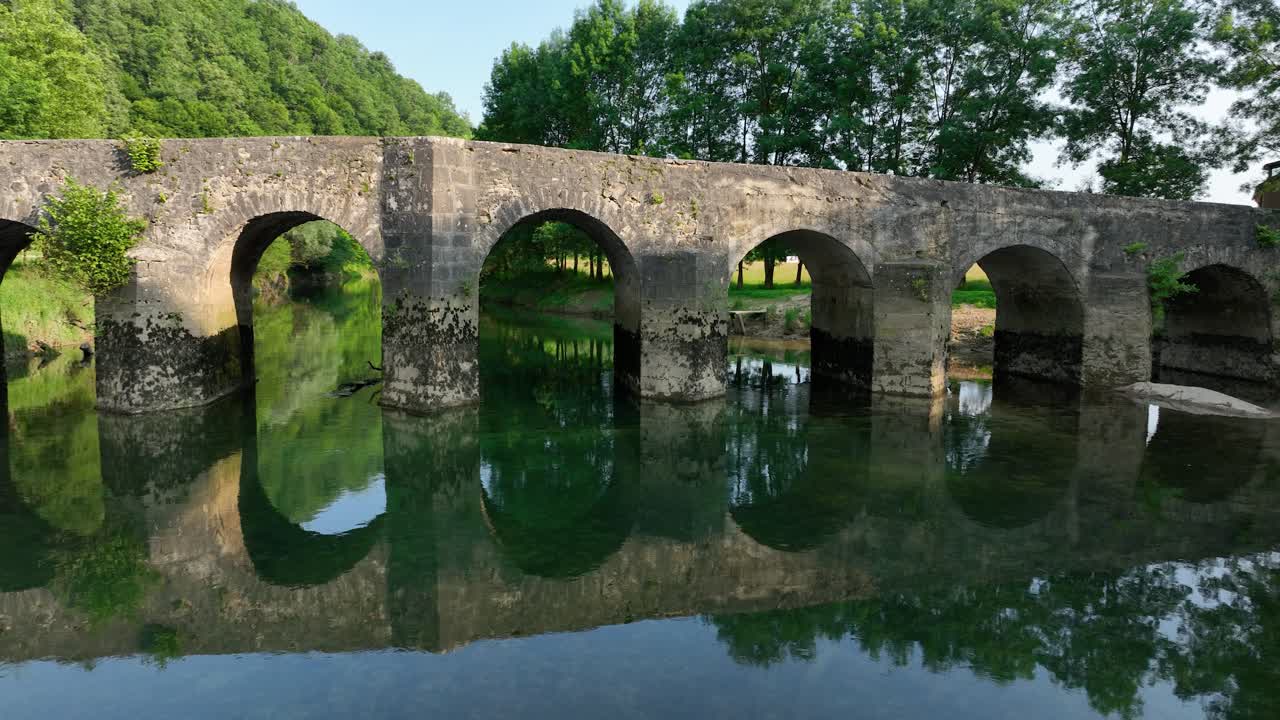 평화로운 시골 환경 에서 강 을 가로지르는 고대 돌 의 아치 다리