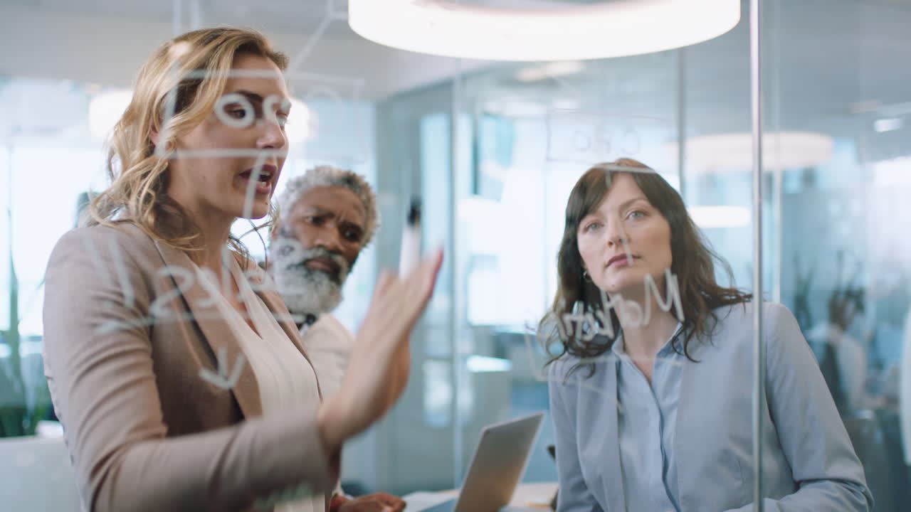 personas de negocios usando notas adhesivas lluvia de ideas líder de equipo mujer trabajando con colegas escribiendo en pizarra de vidrio mostrando estrategia de resolución de problemas en la reunión de la oficina