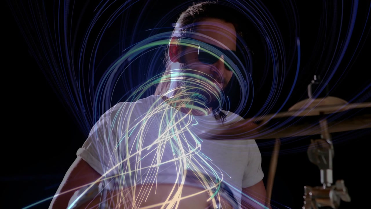 Mid adult male drummer lifting sticks and striking drums for music, neon spiral syncing to hits