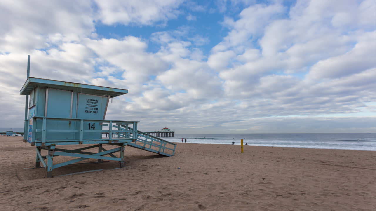 nubes panorámicas sobre el muelle de la playa de manhattan torre de socorristas durante el amanecer en california, ee.uu.