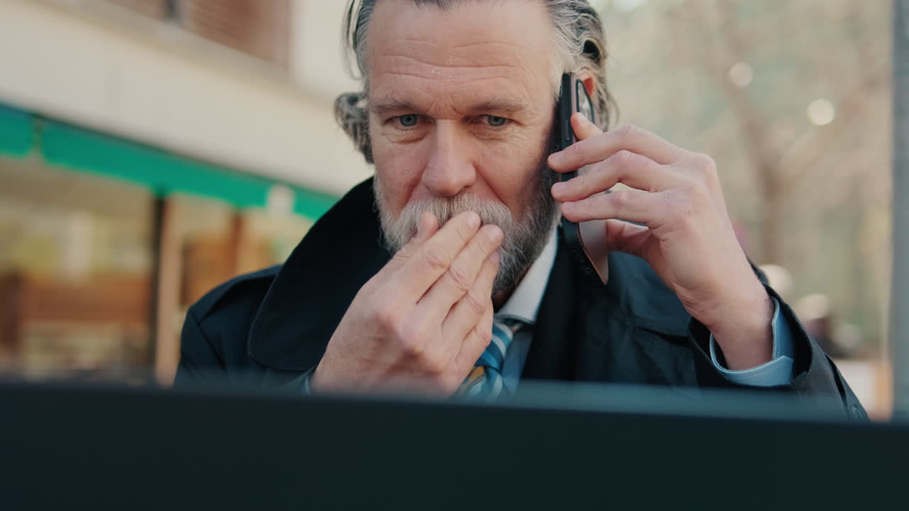 Zakenman die buiten werkt op laptop en telefoon