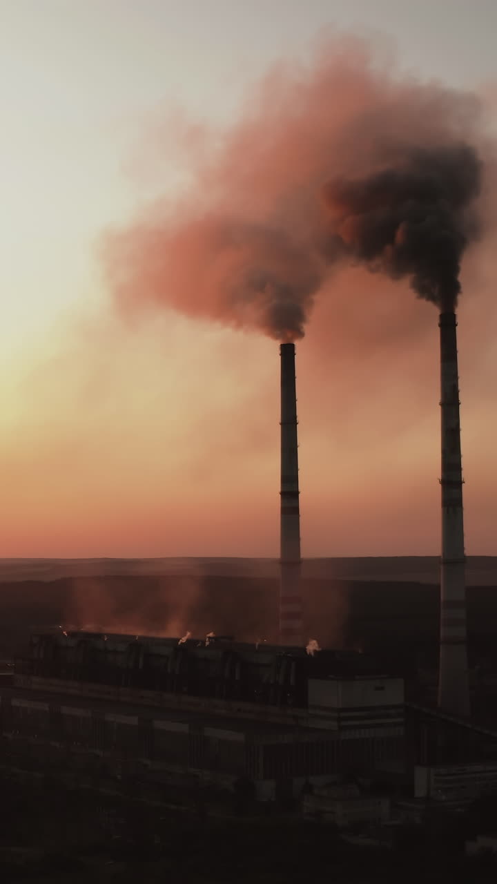 Aerial view of factory with pipes. Aerial view of plant with high factory structure at industrial production area. Vertical video