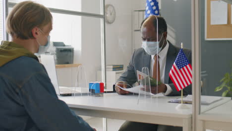 visa officer in mask working in embassy during pandemic