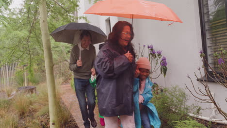 grandparents and grandchildren running in the rain