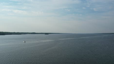 Drone-view-of-a-boat-in-a-lake-on-a-bright-sunny-day