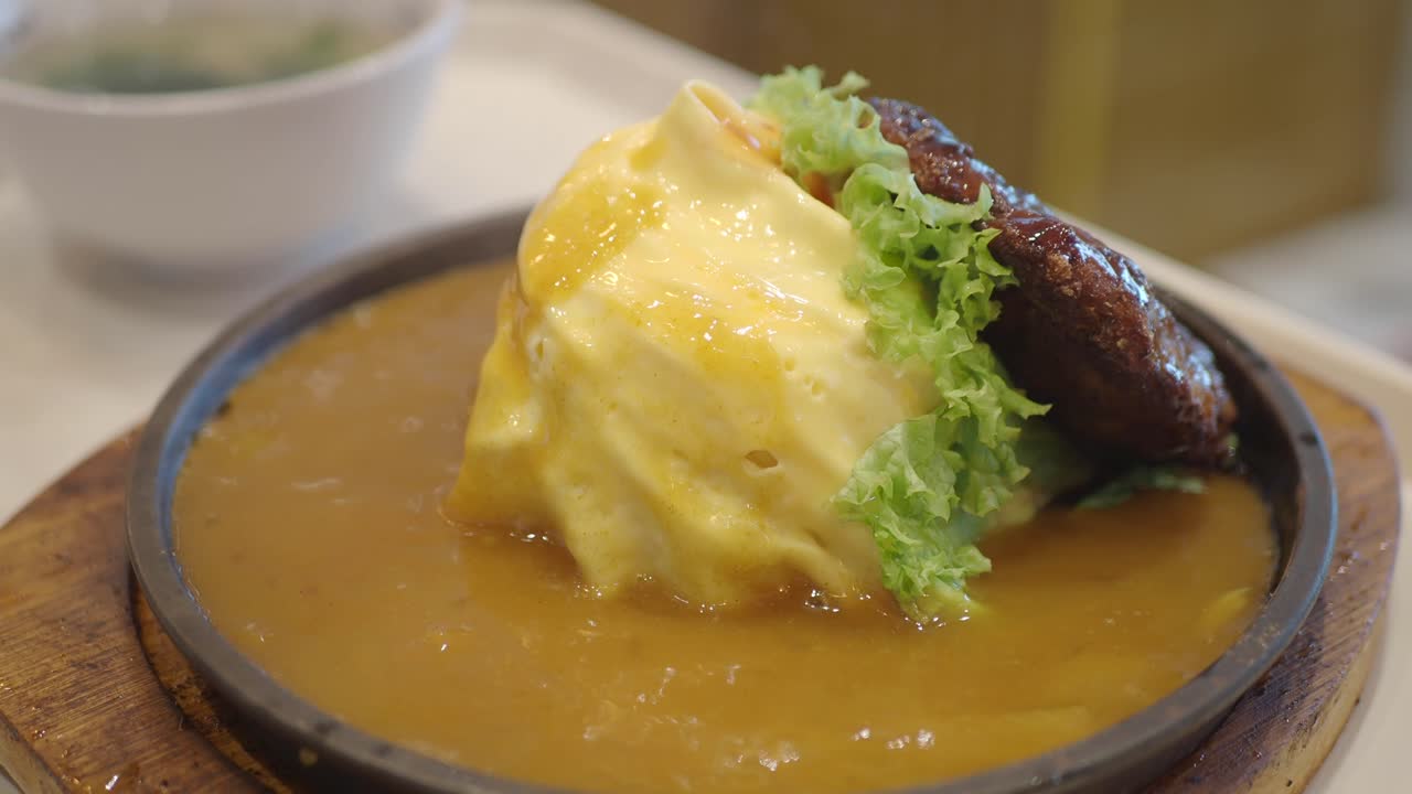 Close up of omelet on plate with sauce and lettuce