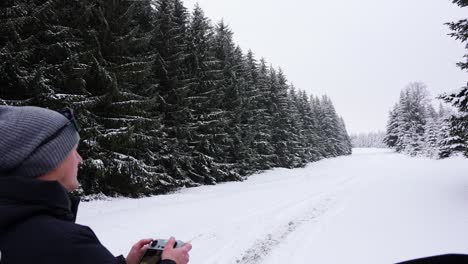 Mann,-Der-Eine-Drohne-Im-Waldbedeckten-Schnee-Fliegt-–-Handaufnahme