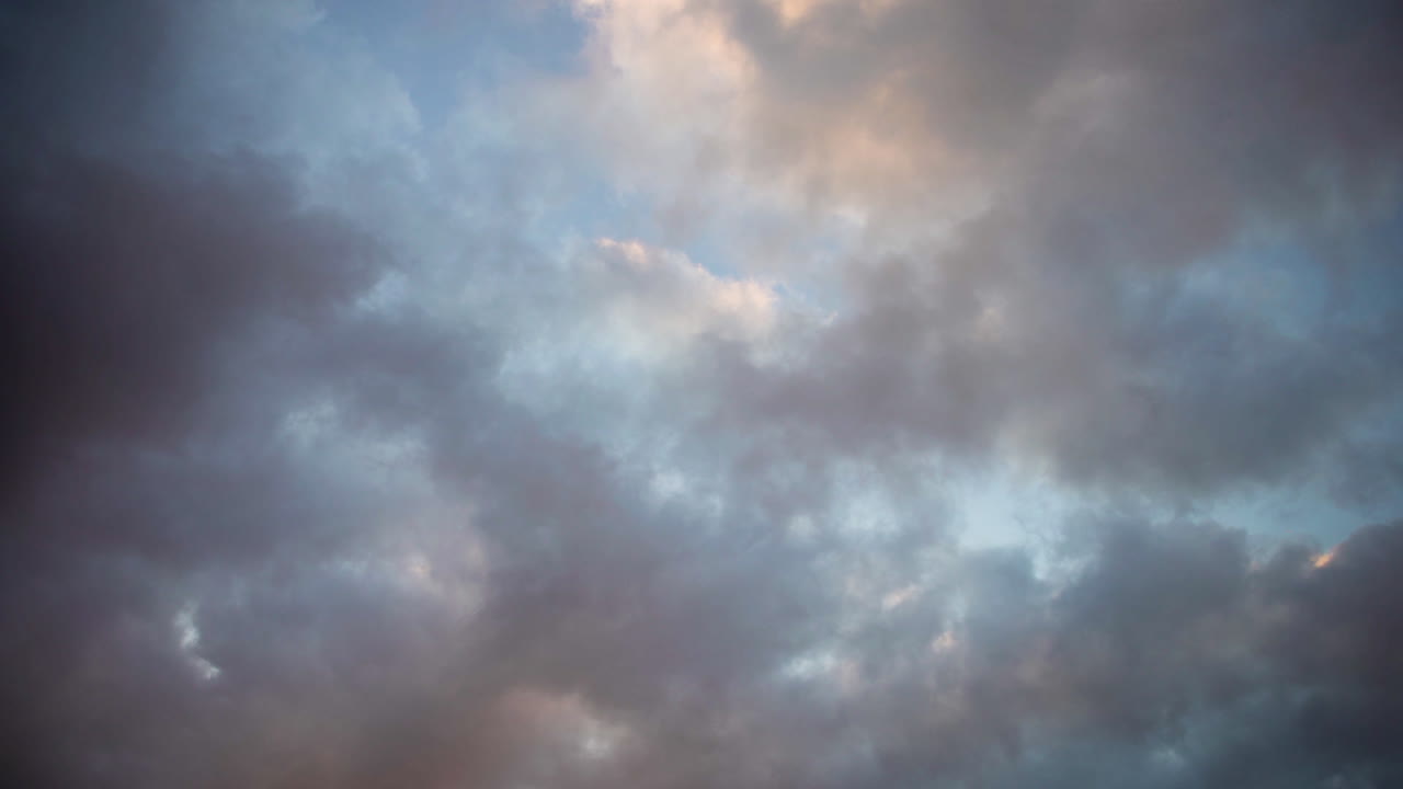 Colorful clouds float passed each other in a dramatic abstract sky background