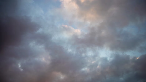 colorful clouds float passed each other in a dramatic abstract sky background