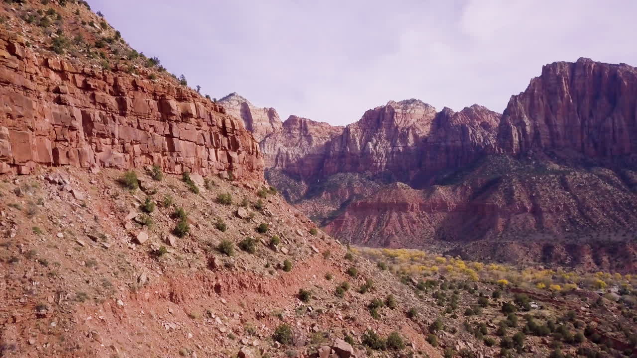 vuelo aéreo más allá de un afloramiento rocoso para revelar un valle épico más allá
